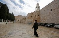 A priest walks past the Church of the Nativity in the West Bank city of Bethlehem a day after spraying sanitizers as a preventive measure against the coronavirus, on March 6, 2020. The city of Bethlehem was on lockdown after the first Palestinian cases of the deadly coronavirus were discovered there. (Photo by Musa Al SHAER / AFP) (Photo by MUSA AL SHAER/AFP via Getty Images)