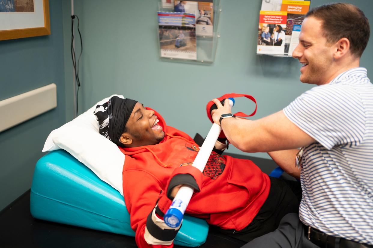 "That's one of my happy places," Damarion Allen says of his physical therapy sessions. His physical therapist, Casey Perch, jokes with Damarion while he pushes him.