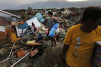 In this Friday, Oct. 5, 2018, photo, a family carries salvageable items they scavenged from the ruins of their house in the Petobo neighborhood which was wiped out by liquefaction caused by an earthquake in Palu, Central Sulawesi, Indonesia. Many in the decimated village had no idea they were in an area already identified as a high-risk zone for this apocalyptic phenomenon that causes soft ground to liquefy during temblors. The area around Sulawesi island's Palu Bay had been slammed before and was due for another potential perfect storm,capable of unleashing earthquakes, landslides, tsunami waves, and soil liquefaction. (AP Photo/Dita Alangkara)