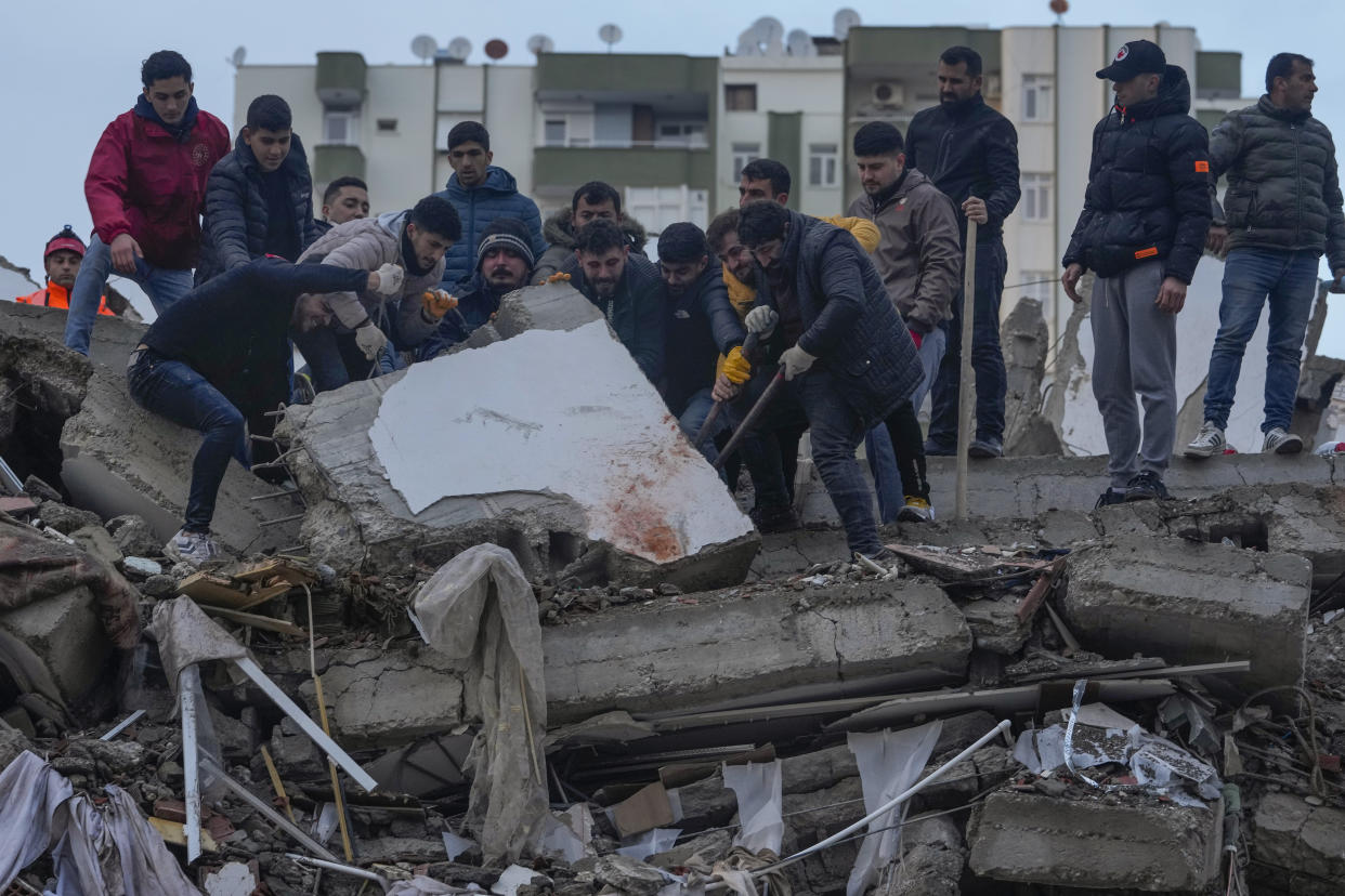 Men searching for people in the debris in Adana, Turkey.