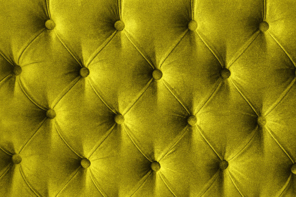 Green-yellow tufted headboard, close-up