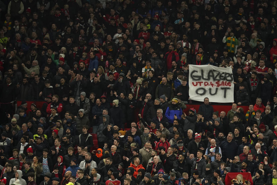 En foto del primero de febrero de 2023, aficionados del Manchester United sostienen una pancarta con la frase "Glazers Out" durante el duelo de vuelta de semifinal de la Copa de Liga. El viernes 17 de febrero del 2023, llega la fecha límite para presentar ofertas para comprar al equipo. (AP Foto/Dave Thompson)