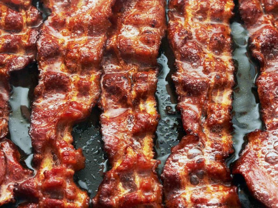 Close up of bacon frying in a pan