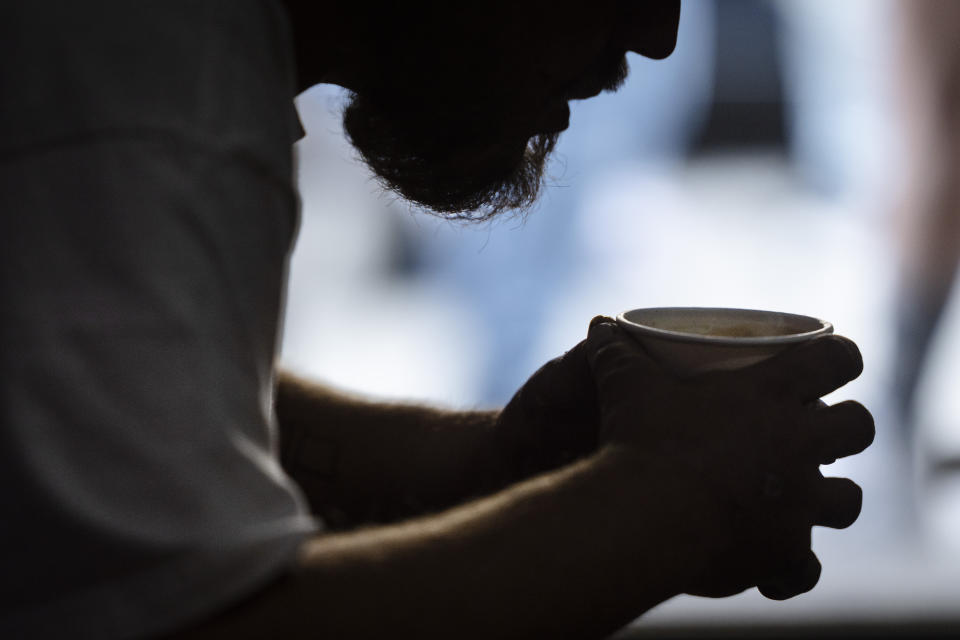 A community member holds a hot cup of coffee at the Savage Sisters' outreach storefront in the Kensington neighborhood of Philadelphia, Wednesday, May 24, 2023. Xylazine, a powerful animal sedative that's moving through the illicit drug supply is complicating the U.S. response to the opioid crisis, causing gruesome skin wounds and scrambling longstanding methods for treating addiction and reversing overdoses. (AP Photo/Matt Rourke)