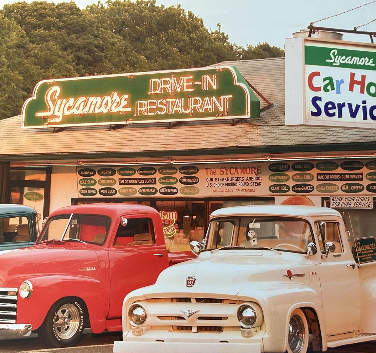 a couple of old cars parked outside a store