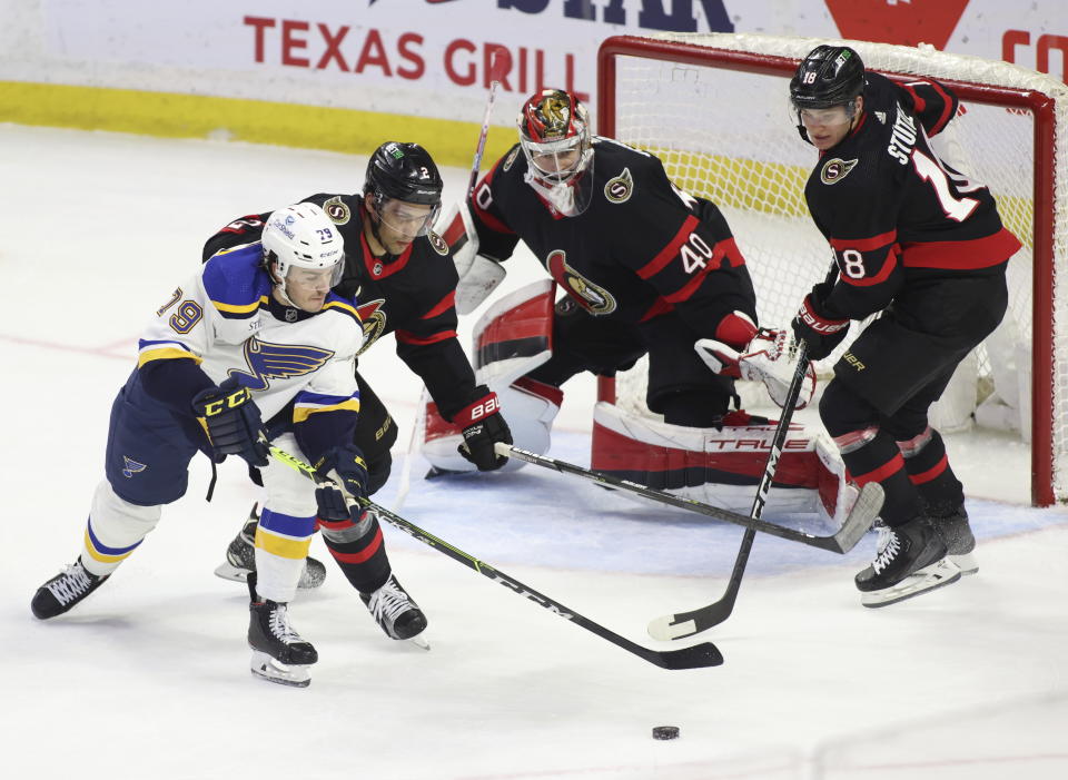 St. Louis Blues' Sammy Blais (79) and Ottawa Senators' Artem Zub (2) and Tim Stutzle (18) eye the puck in front of Senators goaltender Mads Sogaard (40) during the first period of an NHL hockey game Sunday, Feb. 19, 2023, in Ottawa, Ontario. (Patrick Doyle/The Canadian Press via AP)