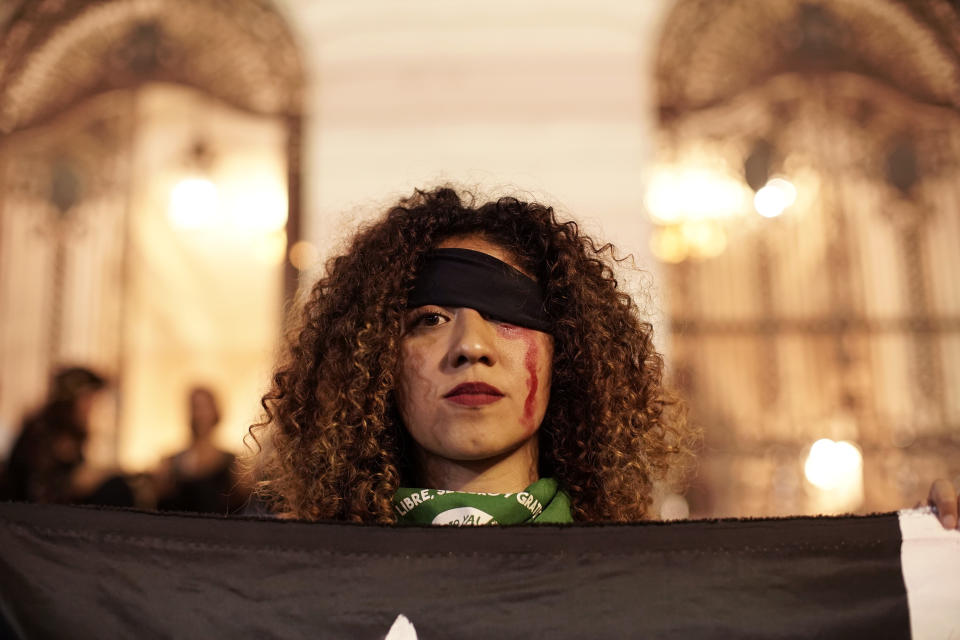 A women takes part in the performing the anthem, "Un violador en tu camino" or "A rapist in your path," in a demonstration against gender-based violence, at Cinelandia Square, in Rio de Janeiro, Brazil, Tuesday, Dec. 3, 2019. The feminist anthem, born in the midst of protests in Chile, continues to expand its popularity throughout the world. (AP Photo/Silvia Izquierdo)