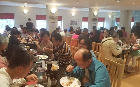 Chinese customers tucking in to their fish and chips - Credit: Charlotte Graham