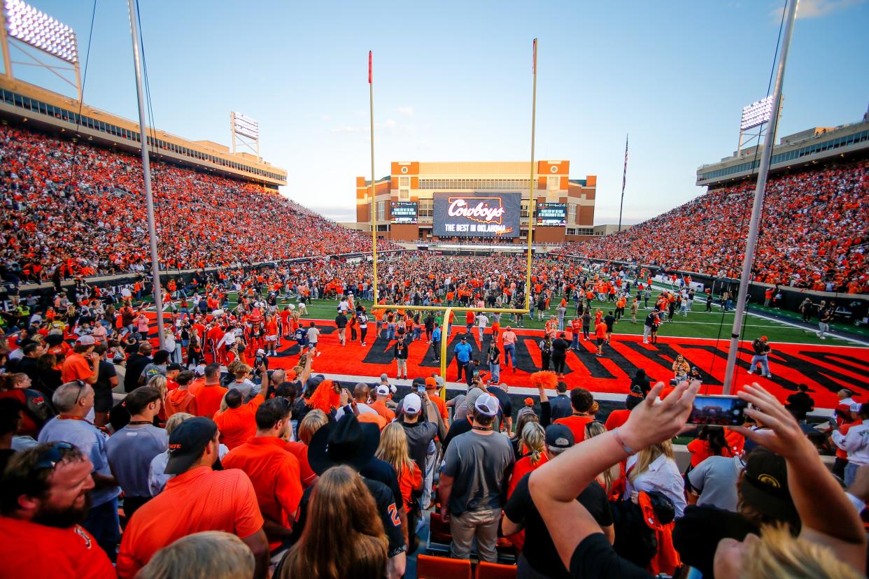 OSU fans storm the field after a 27-24 win against OU on Saturday at Boone Pickens Stadium in Stillwater.