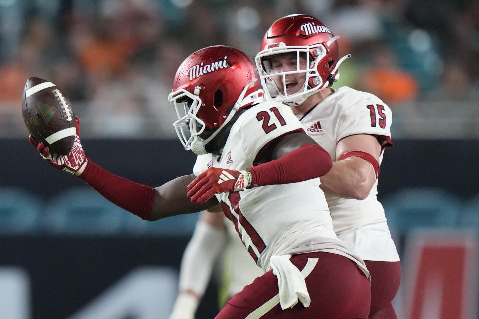 Miami (Ohio) defensive back Michael Dowell (21) celebrates with linebacker Matt Salopek (15) after Dowell intercepted the ball during the first half of an NCAA college football game against Miami, Friday, Sept. 1, 2023, in Miami Gardens, Fla. (AP Photo/Wilfredo Lee)