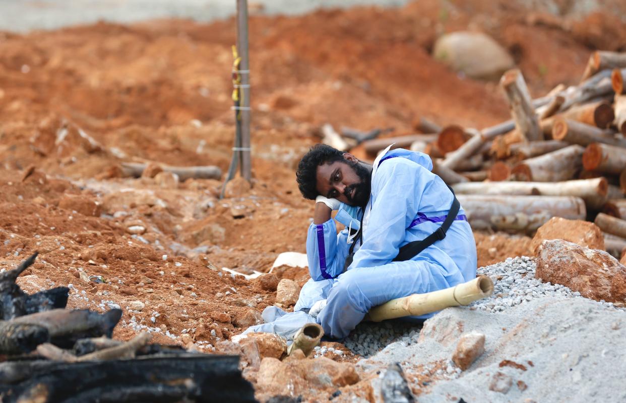 A man wearing PPE (Personal Protection Equipment) waits to perform the last rites of a deceased relative in a new crematorium built to cremate the dead due to Covid-19 on April 28, 2021 in Bengaluru, India.