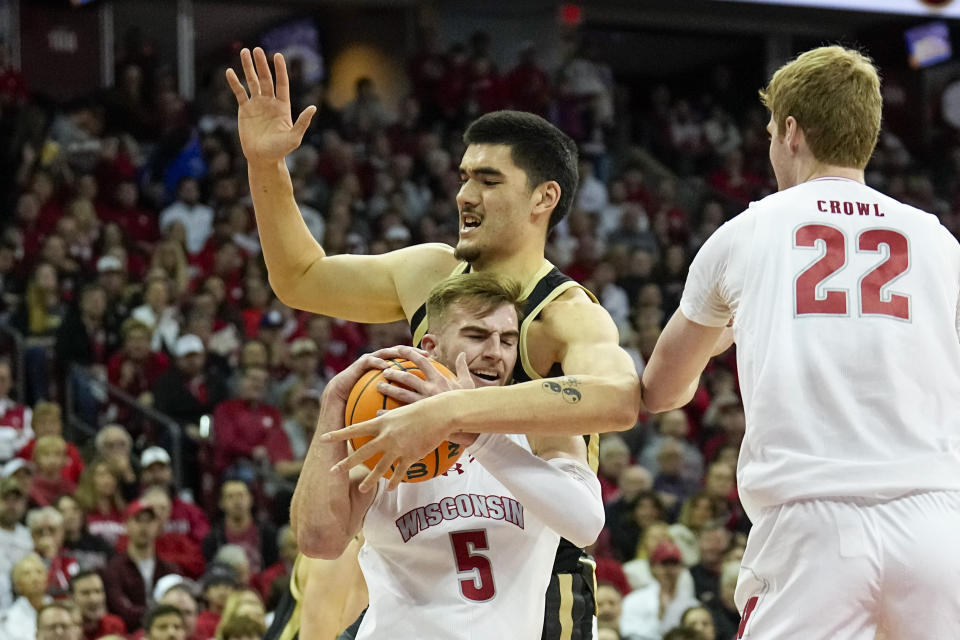 Wisconsin's Tyler Wahl (5) grabs a loose ball away from Purdue's Zach Edey (15) during the first half of an NCAA college basketball game Sunday, Feb. 4, 2024, in Madison, Wis. (AP Photo/Andy Manis)