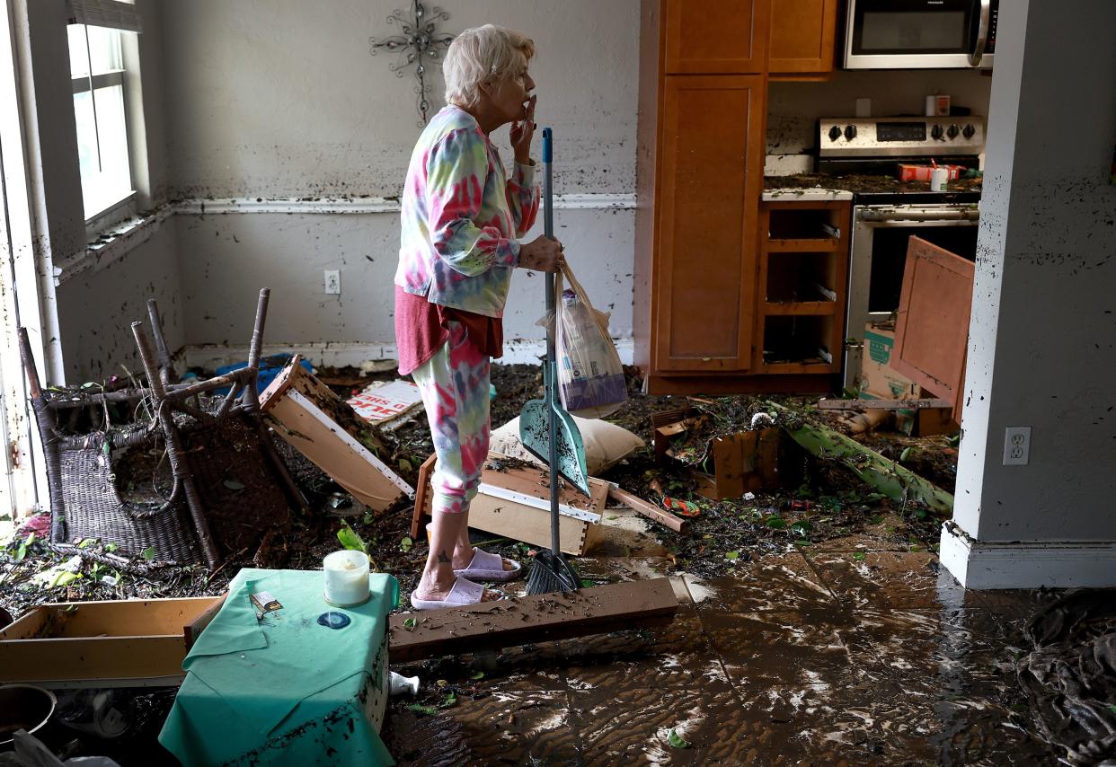 Stedi Scuderi looks over her apartment after flood water inundated it when Hurricane Ian passed through the area on Sept. 29, 2022, in Fort Myers, Fla.