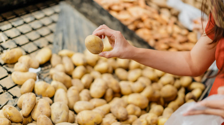 Woman inspecting potatoes in store