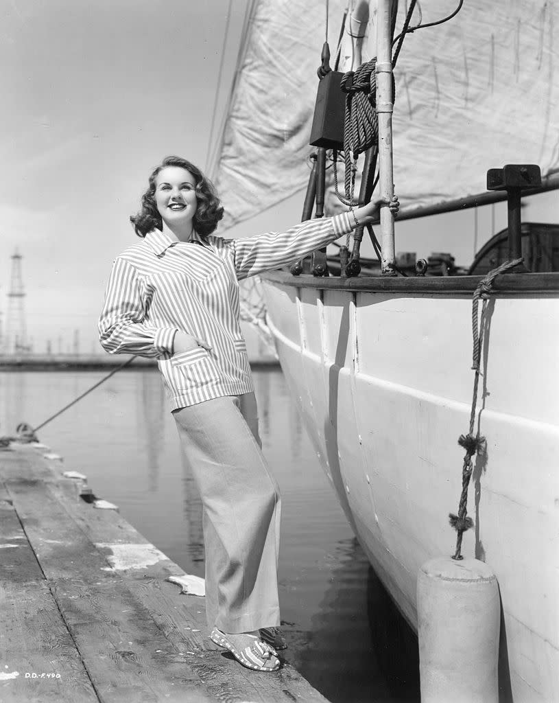 <p>Actress and model Deanna Durbin perfecting a chic sailing look in wide-leg khakis and a striped jacket. </p>
