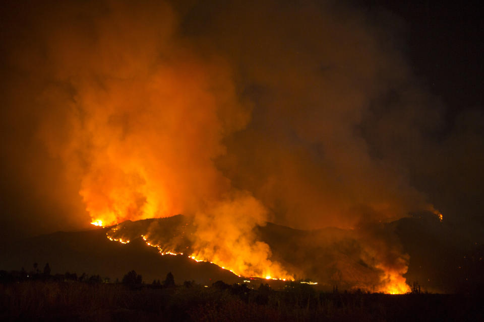 A wildfire burns in Yucaipa, Calif., Saturday, Sept. 5, 2020. Three fast-spreading California wildfires sent people fleeing Saturday, with one trapping campers at a reservoir in the Sierra National Forest, as a brutal heat wave pushed temperatures into triple digits in many parts of state. (AP Photo/Ringo H.W. Chiu)