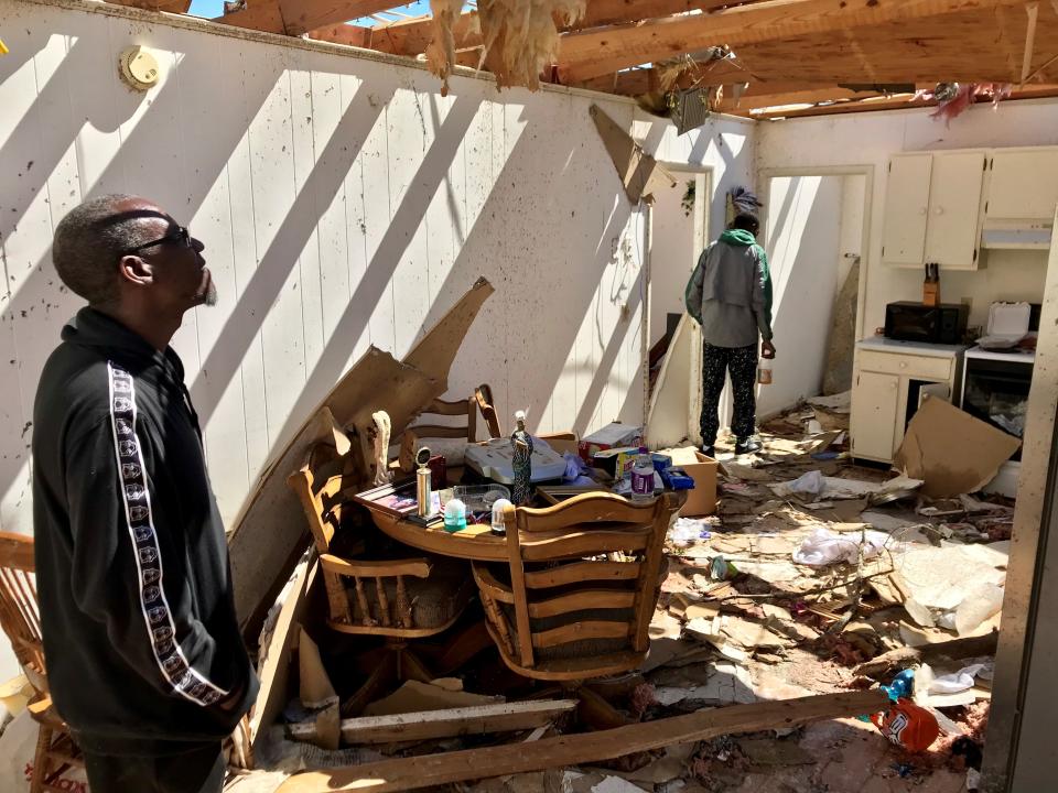 Raymond Sanders and his son Nijal Sanders, 18, walk through the wreckage of their home in Cairo, Georgia, on March 5, 2019, two days after it was nearly destroyed by a tornado.