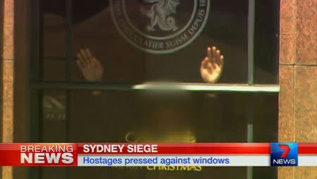 Hands are pressed up against the window of the Lindt cafe, where hostages are being held, in this still image taken from video from Australia's Seven Network on December 15, 2014. REUTERS/Reuters TV via Seven Network/Courtesy Seven Network