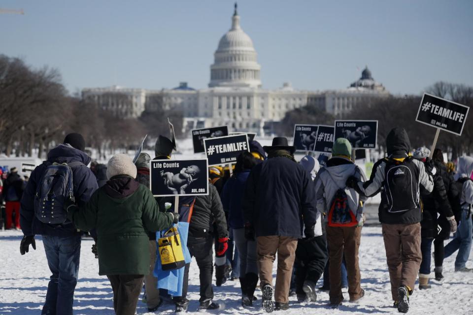 Anti-abortion demonstrators gather on the snow covered National Mall in Washington, Wednesday, Jan. 22, 2014, for the annual March for Life. Thousands of anti-abortion demonstrators are gathering in Washington for an annual march to protest the Supreme Court's landmark 1973 decision that declared a constitutional right to abortion. (AP Photo/Charles Dharapak)