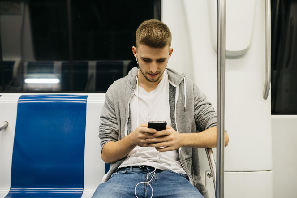 Young man using smartphone in metro