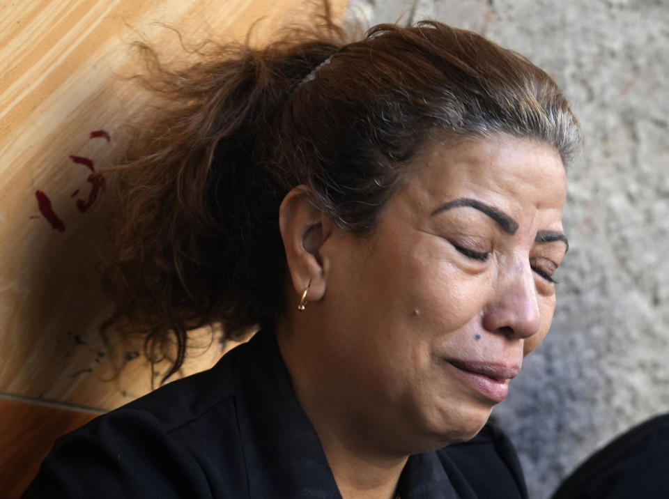 Mariam Habeib, center, who lost 6 relatives in a fire at the Abu Sefein Coptic Christian Orthodox Church that killed 41 people during a Sunday service, cries as she receives condolences outside her house in the neighborhood of Imbaba, one of Egypt’s most densely populated, in Giza, Egypt, Aug. 16, 2022. For Mariam Habeib, the grief is never ending: She lost her older sister, two nieces and a niece's three young children in an intense fire that engulfed a church killing 41 people. (AP Photo/Amr Nabil)