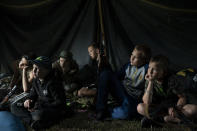 Niños que participan en un campamento de elementos nacionalistas de Ucrania con sus fusiles a su lado escuchan a un instructor el 28 de julio del 2018. En los campamentos les inculcan una ideología nacionalista y les enseñan a combatir a los rusos y sus partidarios. (AP Photo/Felipe Dana)