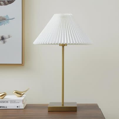 A simple brass lamp with a pleated shade