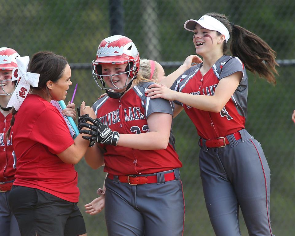 Assistant coach Colleen Doyle and Silver Lake's Alana Waters congratulate Silver Lake's Madyson Bryan, middle, who hit a grand slam to cut the Plymouth North lead to 7-5 in the bottom of the fourth inning of their game against Plymouth North at Silver Lake Regional High School on Friday, May 20, 2022.
