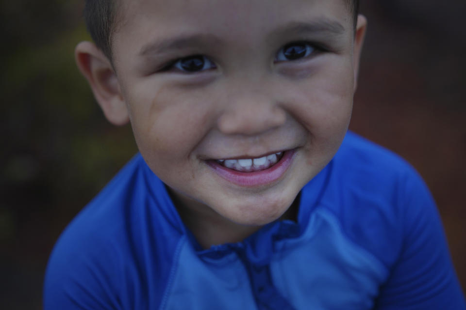 Taivan Kaneko plays along the edges of the Hanapepe salt patch on Kauai Island as his parents wrap up their work at the salt beds on Thursday, July 13, 2023, in Hanapepe, Hawaii. (AP Photo/Jessie Wardarski)