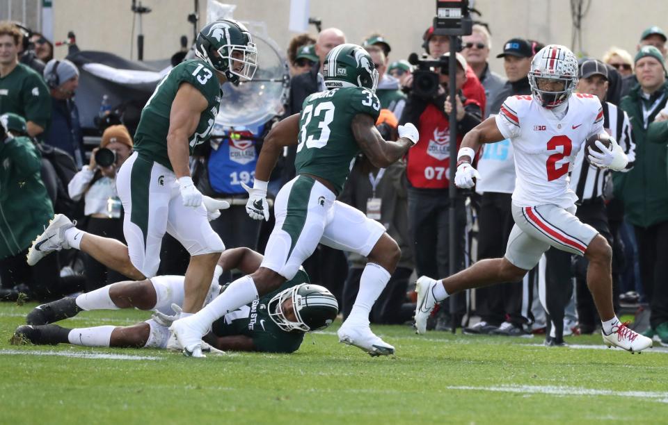 Michigan State Spartans linebacker Jacoby Windmon (4) misses the tackle on Ohio State Buckeyes wide receiver Emeka Egbuka (2) during first-half action Saturday, October 8, 2022 at Spartan Stadium.