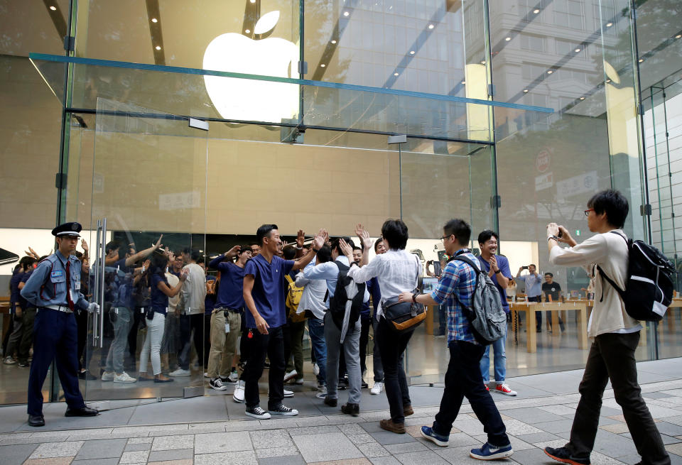 Apple Store staff share high-fives with customers who have been waiting in line to purchase Apple's new iPhone 7 and 7 Plus at the Apple Store in Tokyo's Omotesando shopping district, Japan, September 16, 2016. REUTERS/Issei Kato