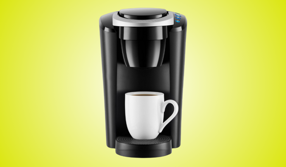 the keurig coffee maker in black on a yellow background