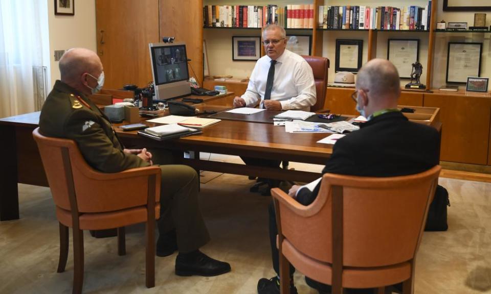 Prime minister Scott Morrison speaks to chief medical officer Paul Kelly and Covid-19 taskforce commander John Frewen