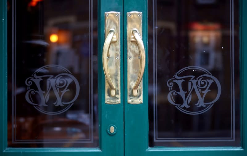 FILE PHOTO: Wetherspoon's logos are seen at the entrance to a pub in central London