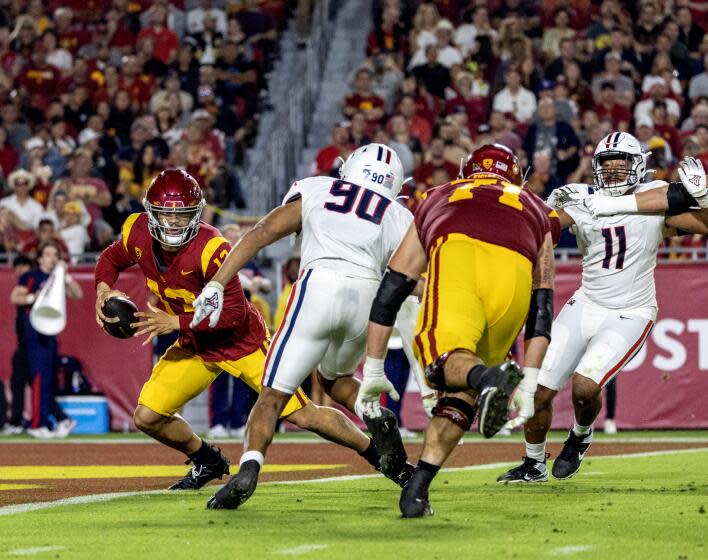 USC quarterback Caleb Williams (13) scrambles out of the pocket as Arizona defensive lineman Isaiah Ward rushes