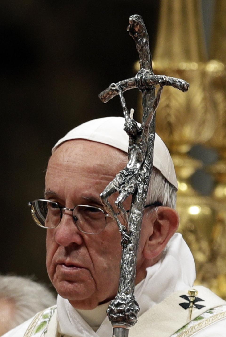 Pope Francis holds a candle as he presides over a solemn Easter vigil ceremony in St. Peter's Basilica at the Vatican, Saturday, April 15, 2017. (AP Photo/Andrew Medichini)