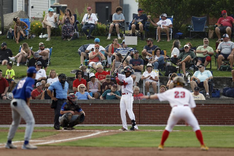 Fans watch the Cape Cod League baseball game between the Chatham Anglers and the Bourne Braves, Wednesday, July 12, 2023, in Bourne, Mass. For 100 years, the Cape Cod League has given top college players the opportunity to hone their skills and show off for scouts while facing other top talent from around the country. (AP Photo/Michael Dwyer)