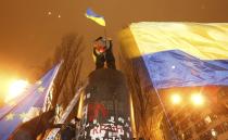 People climb up to the top of a pedestal after a statue of Soviet state founder Vladimir Lenin was toppled by protesters during a rally organized by supporters of EU integration in Kiev, December 8, 2013. Crowds toppled a statue of Soviet state founder Vladimir Lenin in the Ukrainian capital and attacked it with hammers on Sunday in the latest mass protests against President Viktor Yanukovich and his plans for closer ties with Russia. REUTERS/Vasily Fedosenko (UKRAINE - Tags: POLITICS CIVIL UNREST)