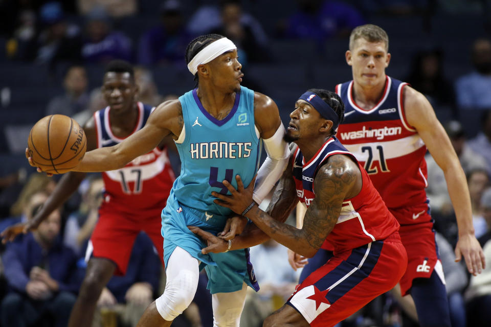 Charlotte Hornets guard Devonte' Graham, left, passes against Washington Wizards guard Bradley Beal in the first half of an NBA basketball game in Charlotte, N.C., Tuesday, Dec. 10, 2019. (AP Photo/Nell Redmond)