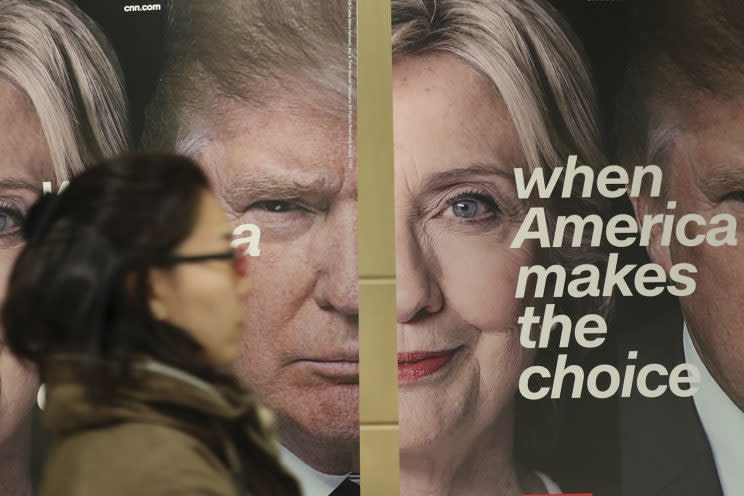 A woman walks by banners of Democratic presidential candidate Hillary Clinton and Republican presidential candidate Donald Trump during an election watch event hosted by the U.S. Embassy in Seoul, South Korea, Nov. 9, 2016. (Photo: Lee Jin-man/AP)