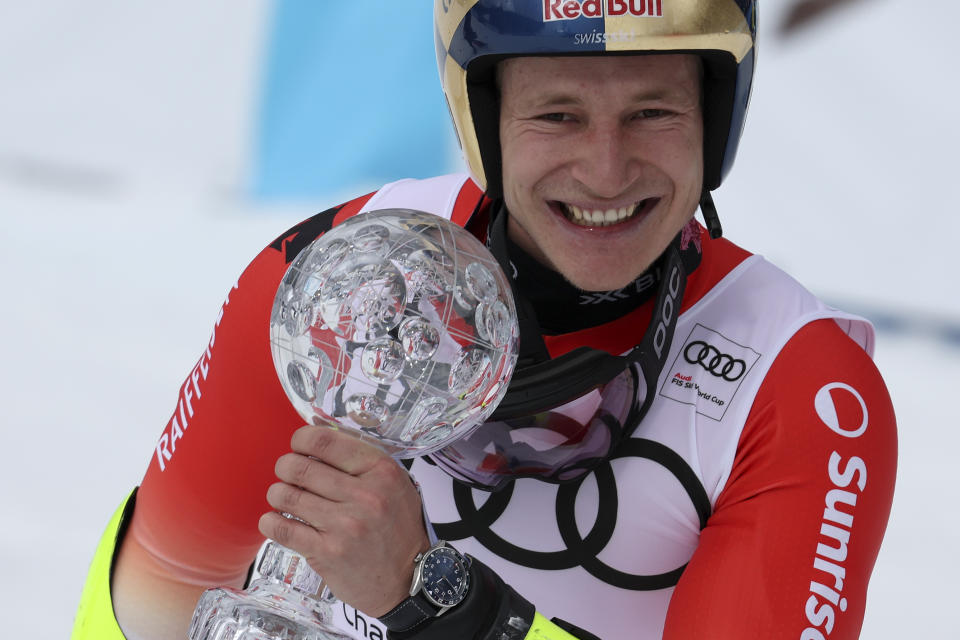 Switzerland's Marco Odermatt holds the alpine ski, men's World Cup giant slalom discipline trophy, in Soldeu, Andorra, Saturday, March 18, 2023. (AP Photo/Alessandro Trovati)