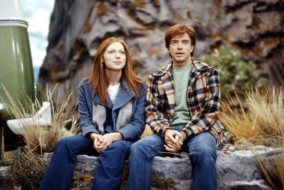 Donna and Eric sit on a rock looking out past them