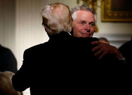 U.S. President Donald Trump hugs Virginia Governor Terry McAuliffe during the Governor's Dinner in the State Dining Room at the White House in Washington, U.S., February 26, 2017. REUTERS/Joshua Roberts