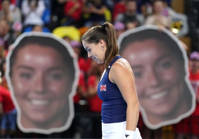 Jodie Burrage stands in front of cut-outs of her own face