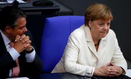 German Economy Minister Sigmar Gabriel (L) listens to Chancellor Angela Merkel as they attend a debate on the consequences of the Brexit vote at the lower house of parliament Bundestag in Berlin, Germany, June 28, 2016. REUTERS/Fabrizio Bensch