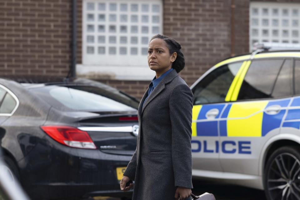 amaka okafor as di barnes in the responder, a woman in a suit walks in front of police cars