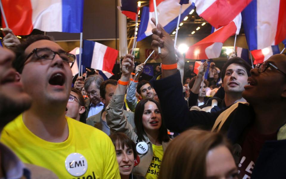 Supporters of French centrist candidate Emmanuel Macron rally at his election day headquarters in Paris - Credit: Thibault Camus/ AP