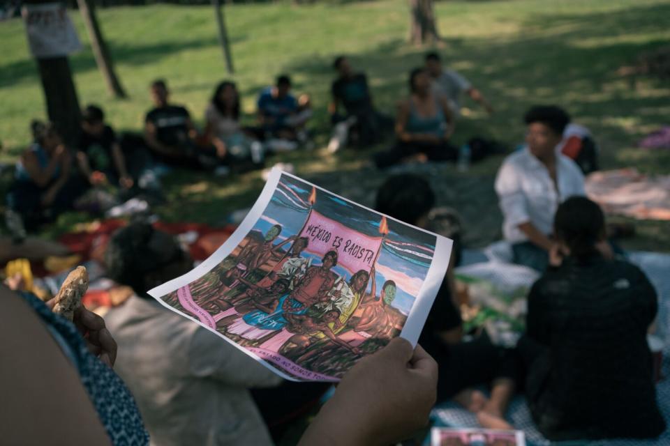 An attendee holds an illustration in a park setting
