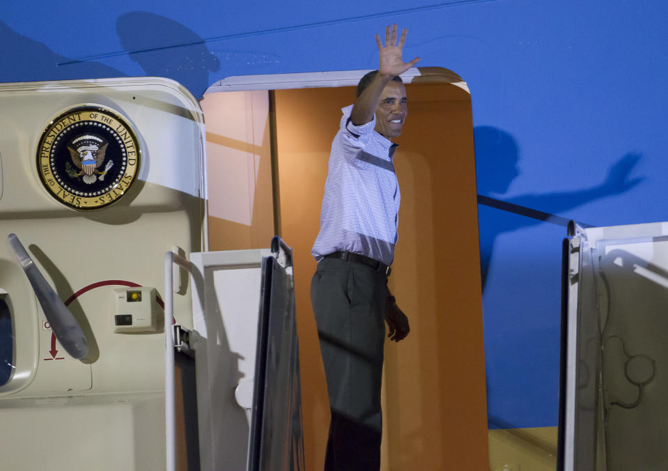 President Barack Obama waves to various Hawaii dignitaries before boarding Air Force One at Joint Base Pearl Harbor-Hickam to return to Washington, Saturday, Jan. 4, 2014, in Honolulu. The President along with his family spent the last two weeks vacationing in Kailua, Hawaii. (AP Photo/Eugene Tanner)