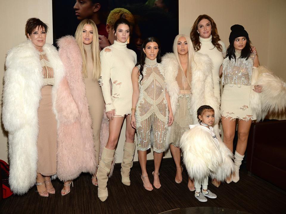 Kris Jenner, Khloe Kardashian, Kendall Jenner, Kourtney Kardashian, Kim Kardashian, Caitlyn Jenner, Kylie Jenner, and North West dressed in white, cream, blush, and crystal ensembles.
